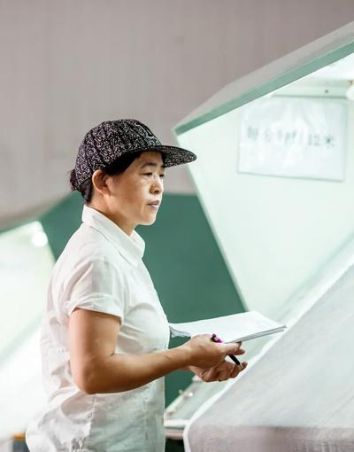 a woman in a hat holding a pen and a clipboard