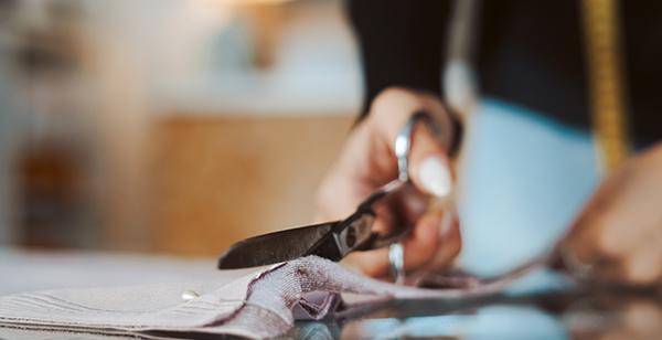 a person cutting fabric with scissors